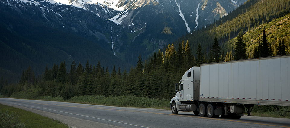 Truck in highway with mountains in the background